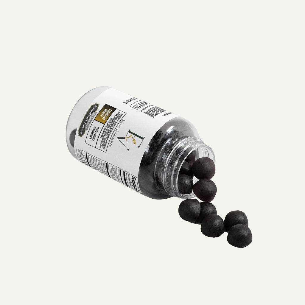 Bottle of black dog treats with a label on a white background